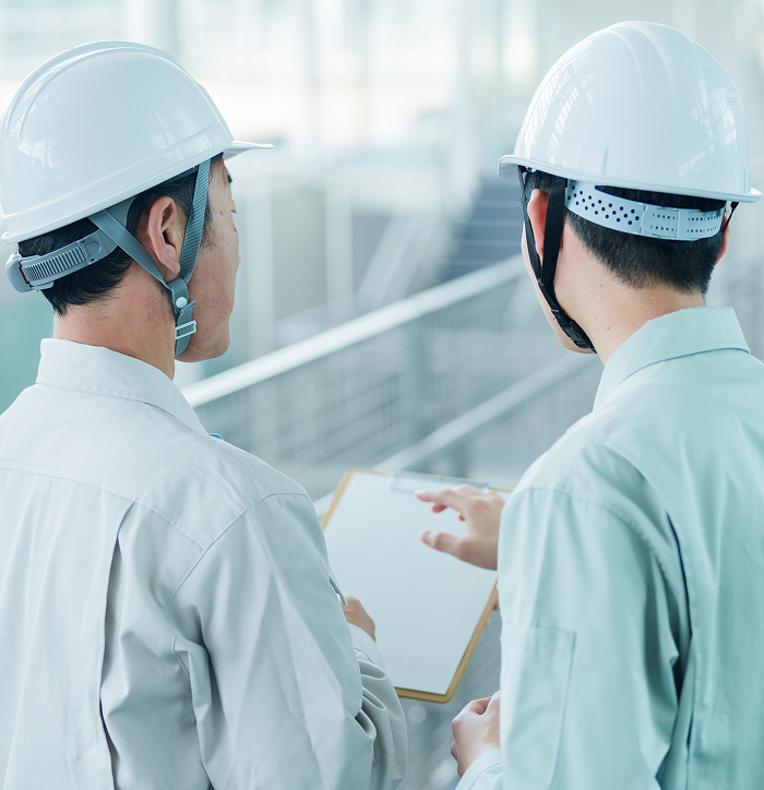 現場で打ち合わせをする職人のイメージ